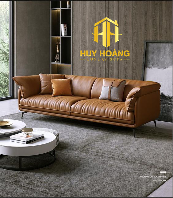 Sofa văng da bò màu nâu cổ điển, kiểu dáng bo tròn, đệm êm, đến từ xưởng Sofa Huy Hoàng.